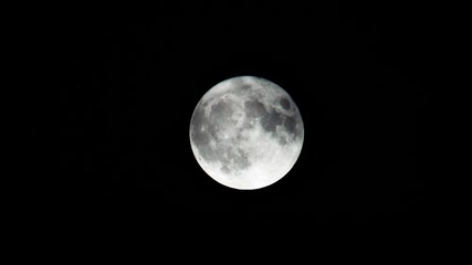 Wall Mural - Full shining moon behind transparent clouds observed through a telescope