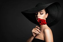 Beautiful Woman And Red Flower, Elegant Lady In Black Wide Broad Brim Hat Smelling Rose