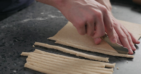 Wall Mural - man cutting flat dough with knife