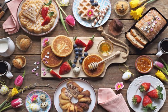 easter festive dessert table with various of cakes, pancakes, waffles and sweets.