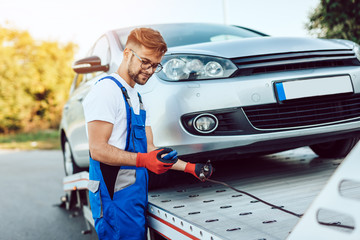 Wall Mural - Handsome middle age man working in towing service on the road. Roadside assistance concept.