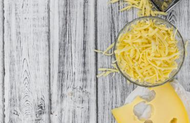 Canvas Print - Wooden table with grated Cheese (close-up shot)