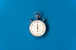 Old mechanical stopwatch on blue paper background