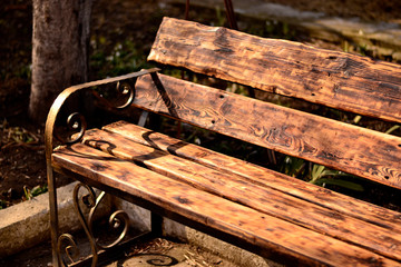 Brown wooden bench with forged legs