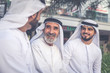 © oneinchpunch - Three business men walking in Dubai wearing traditional emirati clothes
