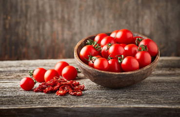 Dried ans fresh tomatoes on wooden background