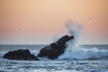 Wild Waves Hitting A Rock In A Beautiful Sunset