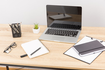 Front view of creative designer desktop with laptop ,notebook , supplies.