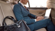 © Svitlana - Busy businessman. Cropped photo of a man in full suit working on his laptop while sitting in the car
