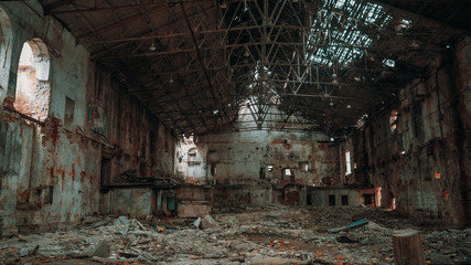 Inside ruined and abandoned large creepy industrial factory warehouse hangar, toned