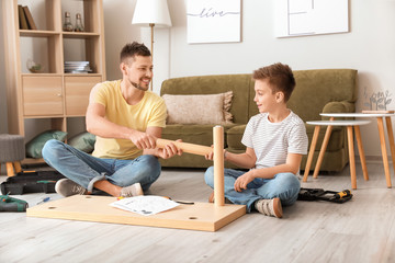 Wall Mural - Father and his little son assembling furniture at home