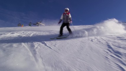 Wall Mural - girl skier skiing on slopes in the Swiss alps, sun rays and flare in the background