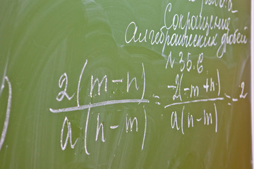 mathematical formulas on a green school Board. 