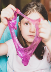 KId play with Homemade Slime. Toy for children mucus and liquid flowing on hand. Close up. Slime toy