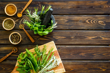 Wall Mural - Making spices. Herbs in motar and dry flavorings on dark wooden desk top-down copy space