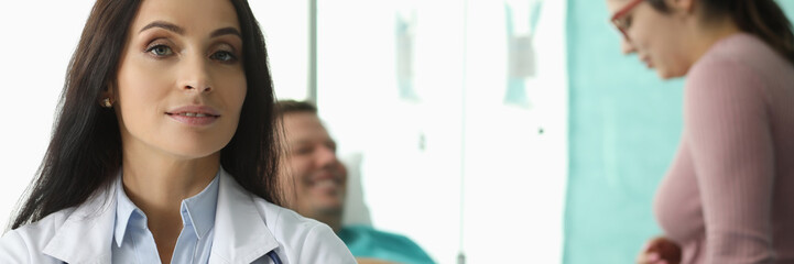 Wall Mural - Portrait of wonderful woman looking at camera with calmness. Smiling wife speaking with ill husband about diagnosis. Healthcare and treatments concept