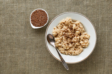 Wall Mural - Oatmeal with flaxseeds on a textile background