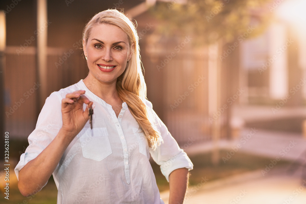 Beautiful mature woman holding key to her new home Stock Photo | Adobe ...