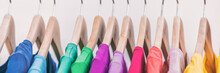 Clothes On Clothing Rack Panoramic Banner. Women's Wardrobe Fashion Apparel Rainbow Organized T-shirts By Colors Hanging On Closet Hangers. Shopping Spring Cleaning. Panorama Background.