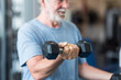 © Daniel - close up of mature man holding two dumbbells doing exercise at the gym to be healthy and fitness - portrait of active senior lifting weight