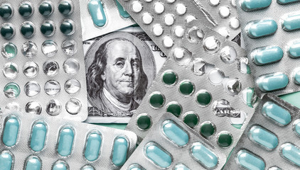 Wall Mural - Benjamin Franklin's head with dollar bills looks among blisters with Aqua Menthe pills, medicine flat lay