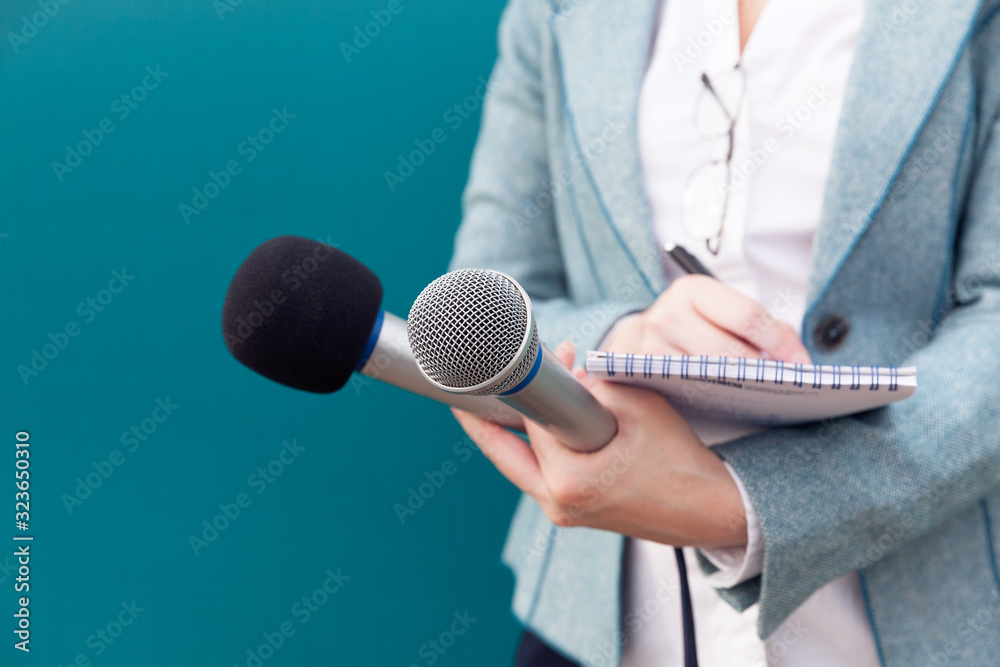 News reporter or TV journalist at press conference, holding microphone and writing notes - obrazy, fototapety, plakaty 