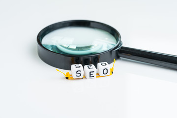 Aufkleber - SEO, Search Engine Optimization, website promotion and social discovery concept, miniature forklift arrange cube block building the word SEO on magnifying glass