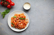 © olsima - Tasty appetizing classic italian spaghetti pasta with tomato sauce, cheese parmesan and basil on plate on grey backgroound
