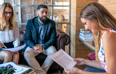 Wall Mural - Business people having an informal work meeting sitting on the couch. Selective focus on woman in foreground