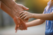 © maeching - Nature a parent holds the hand of a small child