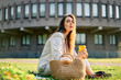 © GVS - Young stylish woman drinking coffe and relax sitting on a grass in city park