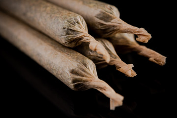 Cannabis Marijuana Rolled in Joints on Dark Reflective Background