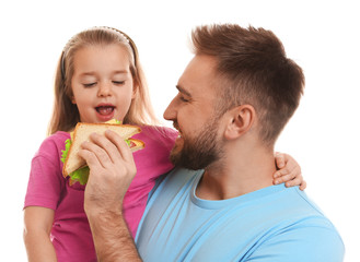 Wall Mural - Young man and his daughter with sandwich on white background