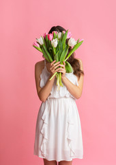 Canvas Print - Young Girl Hiding Face Behind Bouquet Of Tulips In Her Hands