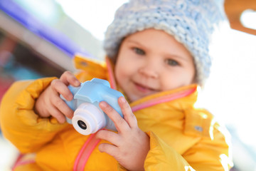 Poster - Cute little photographer outdoors, focus on hands with camera