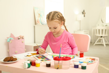 Sticker - Cute little child painting at table in room