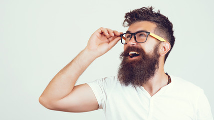 Handsome man in glasses thinks. Emotion surprise. Positive pleased hipster being in good mood after successfully passed exams or tests.