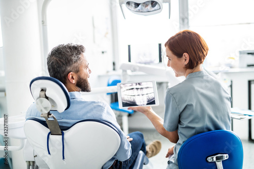 Obraz Dibond Widok z tyłu człowieka i dentysty w chirurgii stomatologicznej, coroczne badanie kontrolne.