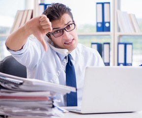 Businessman with excessive work paperwork working in office