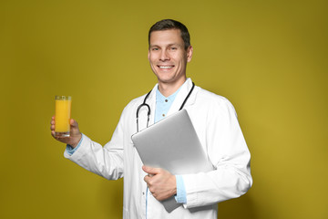 Poster - Nutritionist with glass of juice and laptop on yellow background