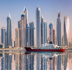 Wall Mural - Panorama of Dubai with ship against skyscrapers in UAE