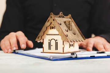 man hand house model on document