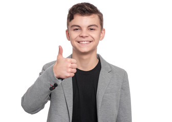 Wall Mural - Handsome Teen Boy in suit making Thumb up Gesture. Portrait of caucasian Smiling Teenager isolated on white background. Happy child looking at camera.