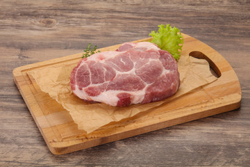 Raw pork steak over wooden board