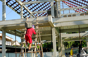 man worker moving lift roof tiles on stair to second floor for prepare install building house roofs