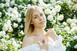 © Andrii - girl in a white dress in the garden with white roses