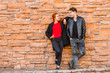 © kpn1968 - A young man and a girl stand with their backs to a stone wall