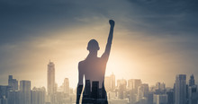 Confident Young Woman With Fist In The Air Facing The City. People Power And Strong Young Woman Concept 