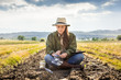 © MACO - Biologist sitting in field, inspecting crops and soil samples with tablet. Bridger, Montana, USA