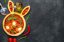 Easter Pizza In The Form Of A Hare With Eggs, Tomatoes, Sunflower Oil On A Stone Background With Copy Space For Your Text